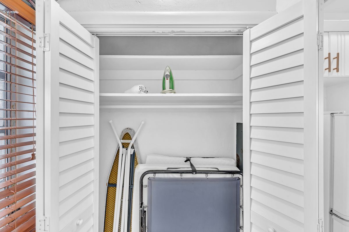 The closet, with an ironing board and beach chair