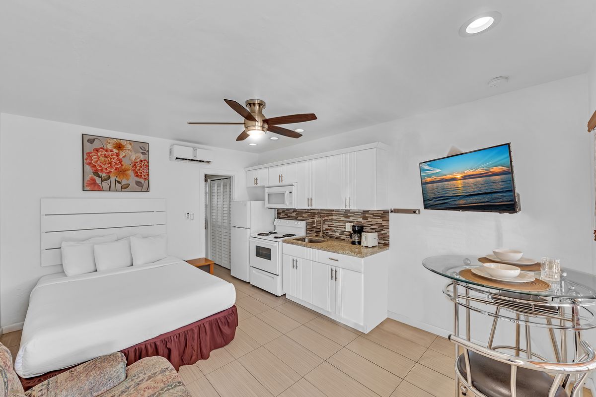 A queen bed and the full kitchen in one room