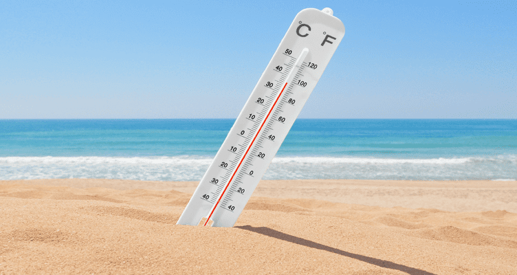 Enjoying Florida's summer heat thermometer in the sand on the beach