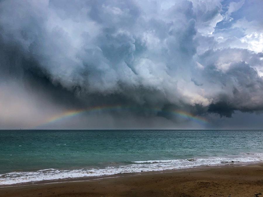 Florida hurricane season - beautiful rainbow in the dark clouds over the ocean